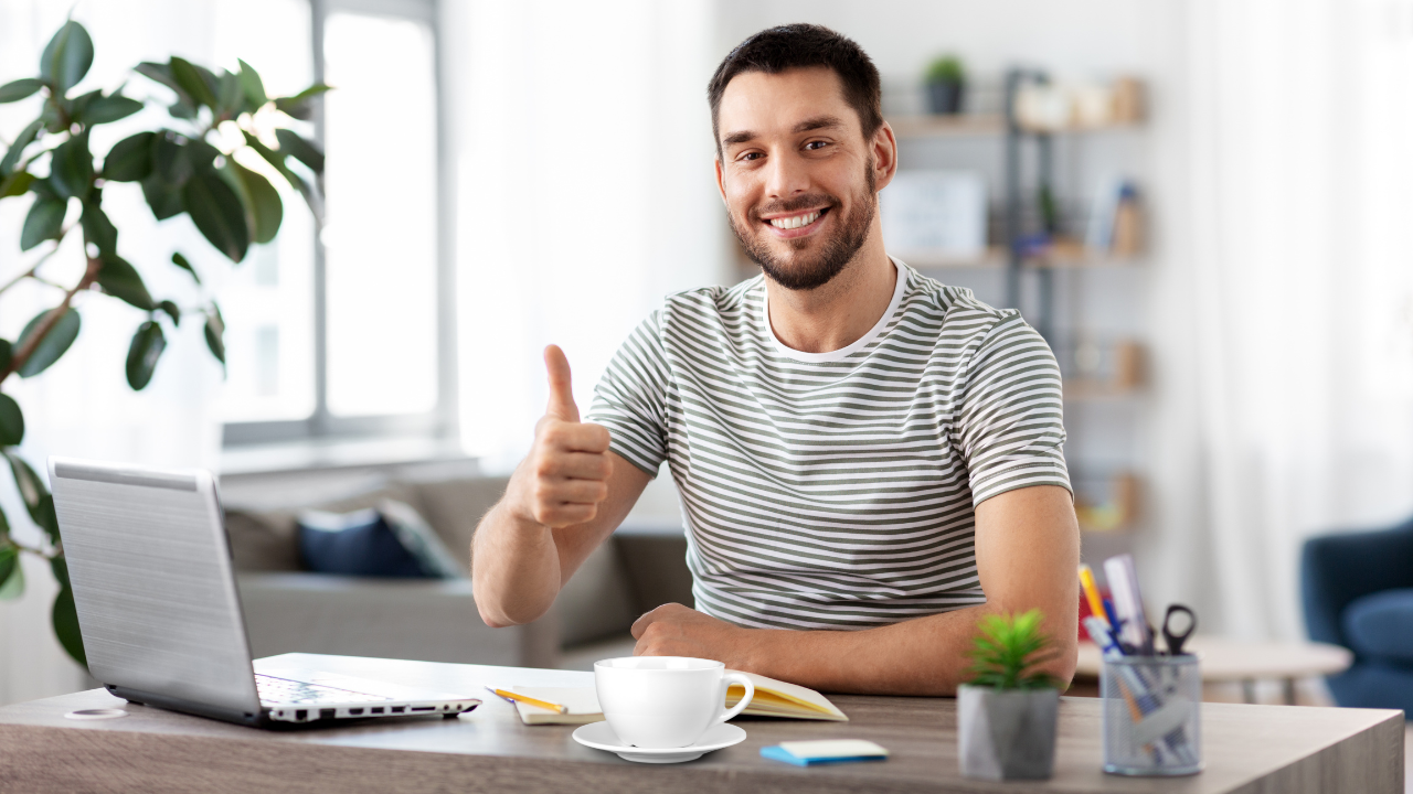 Freelancer trabajando en una oficina privada con un café y su laptop.