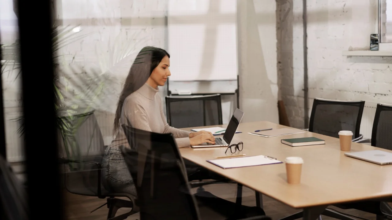 mejores salas de reuniones: mujer concentrada en su computador